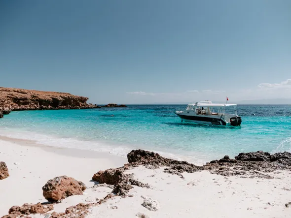 Turquoise bay with a boat on the Omani coast